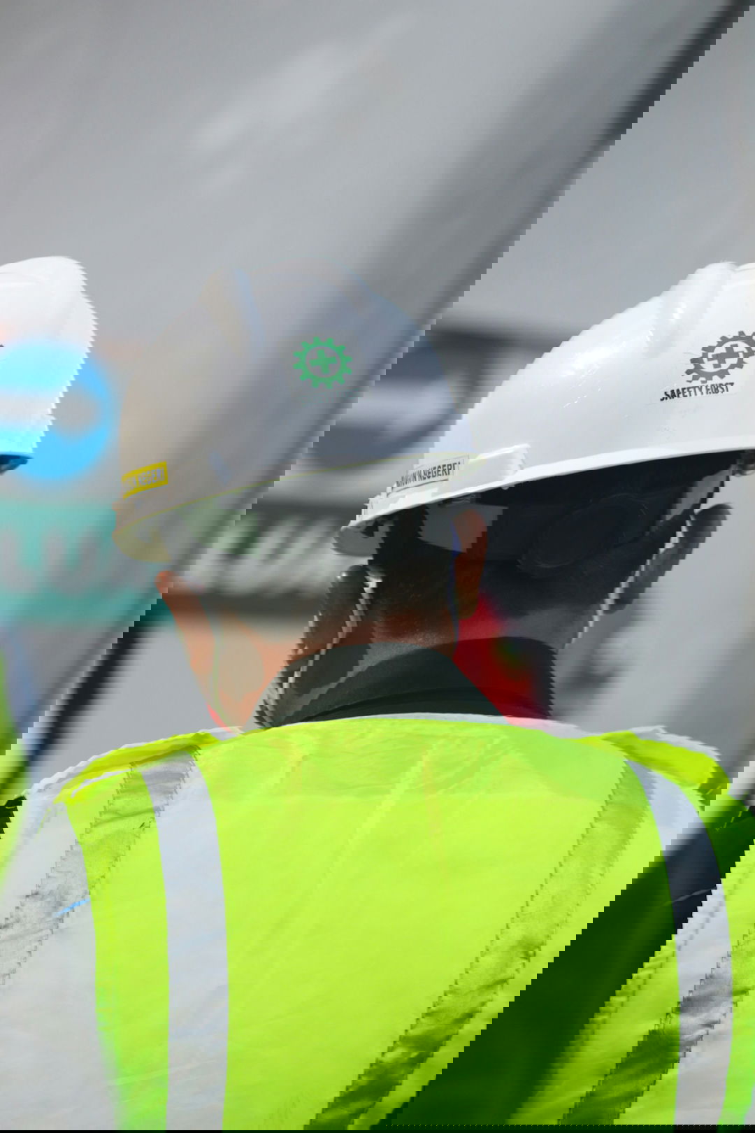 man in yellow and black vest wearing white helmet